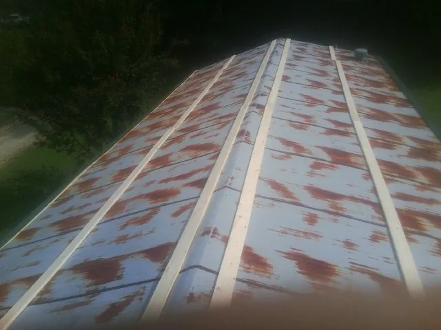 Rusted metal roof panels with new wood purlins before replacement — Storm Damage Roof Repair in Center Junction by Roofing Brothers