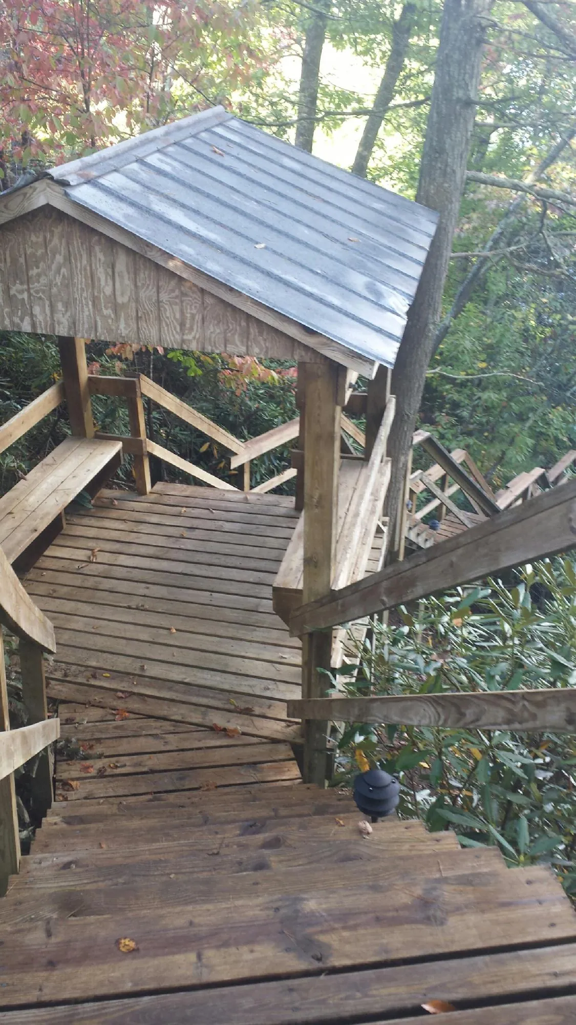 Metal roofed shelter over wooden steps on a wooded walkway — Skylight Repair & Installation work by our crew in Center Junction
