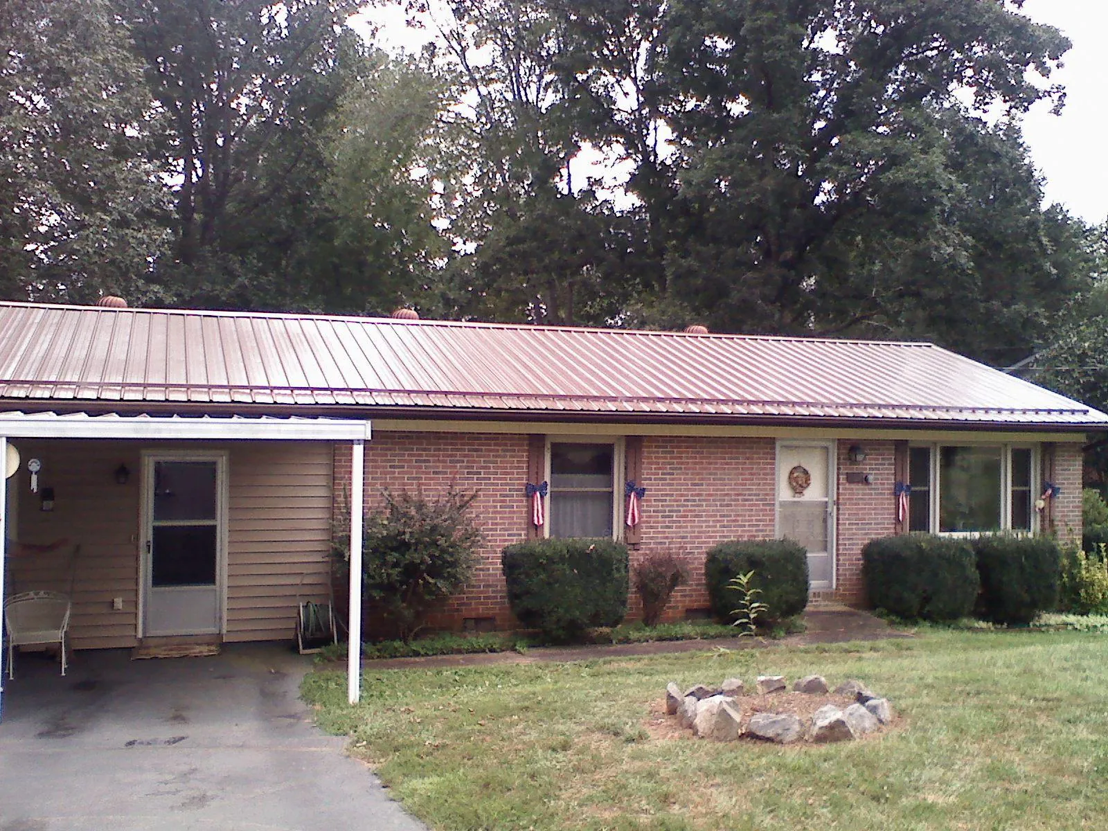 Bronze metal roof and carport on a brick ranch home — Roof Repair work by our crew in Center Junction